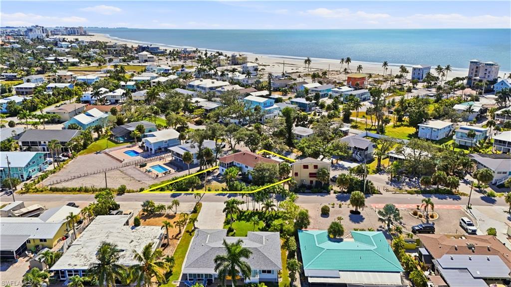 Aerial view of residential area with property boundaries highlighted and expansive beach - Virtually Edited Image