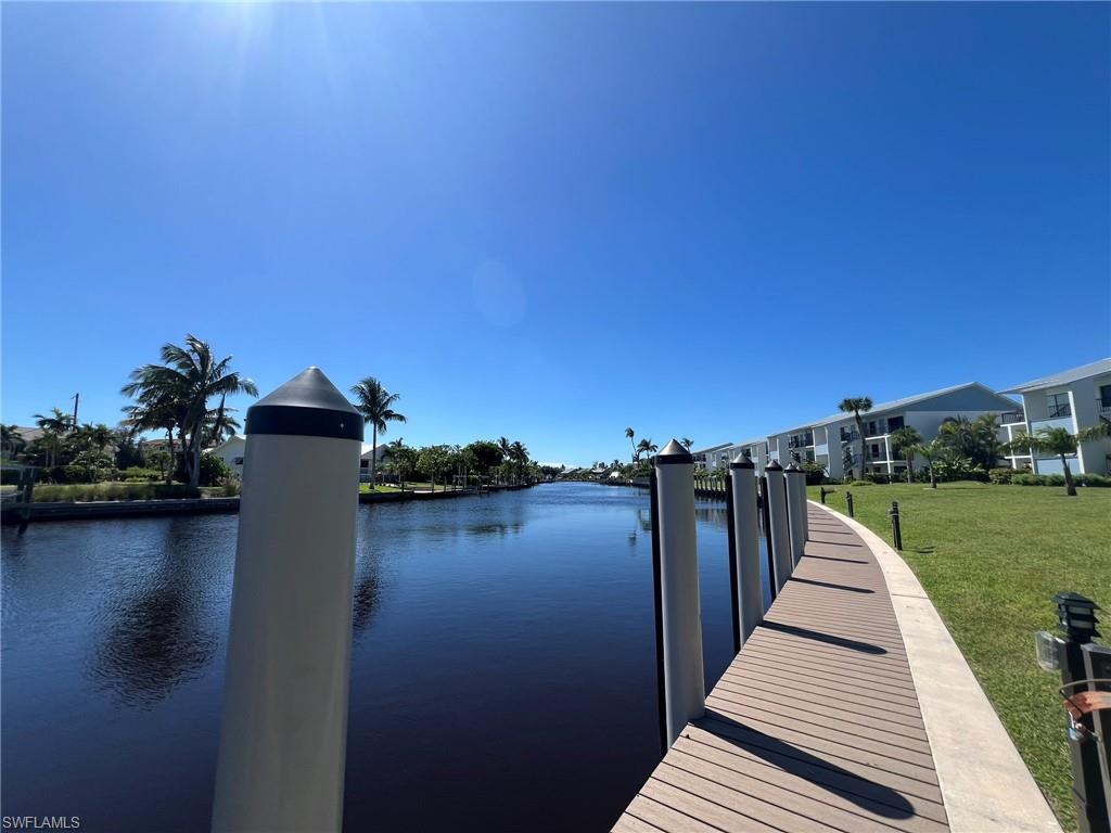 Dock with a water view and a yard