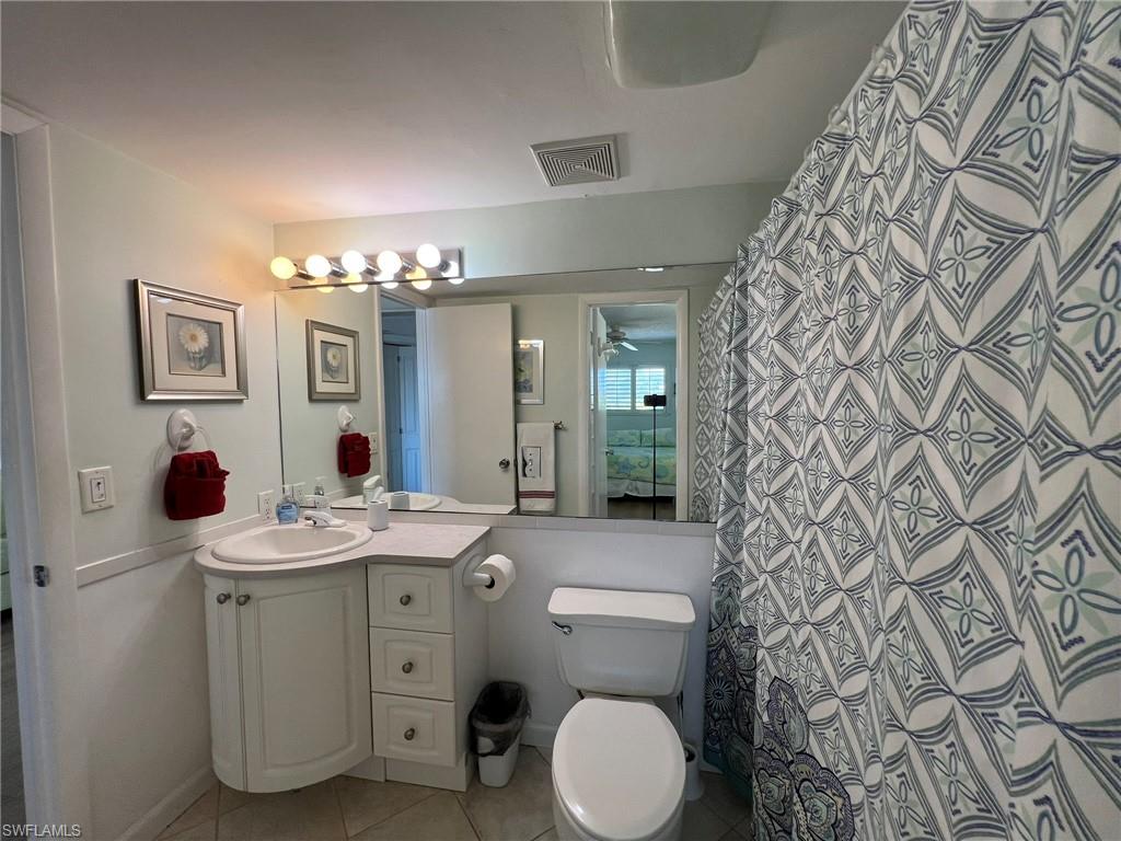 Bathroom with vanity, a shower with shower curtain, and light tile patterned floors