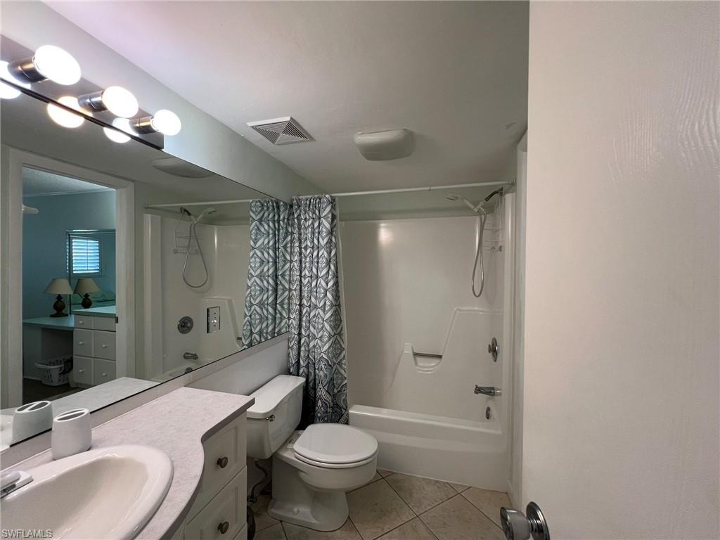 Full bath featuring vanity, light tile patterned floors, and shower / bath combination with curtain