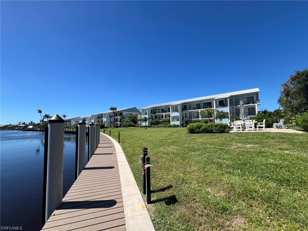 Dock featuring a lawn and a water view