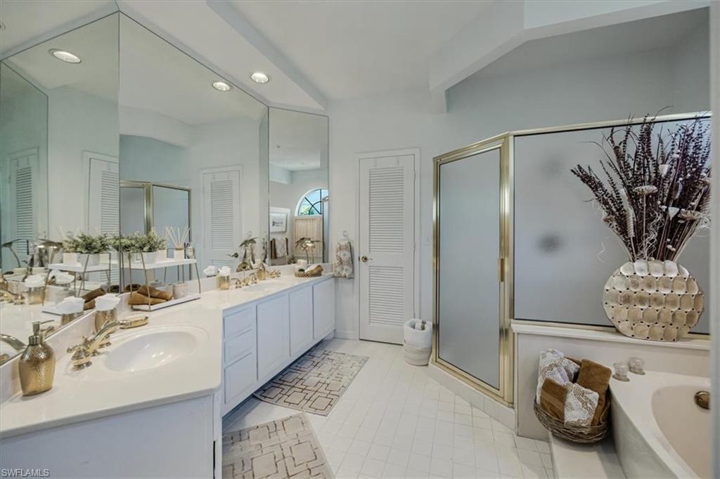 Full bathroom with recessed lighting, a shower stall, light tile patterned floors, a garden tub, and double vanity