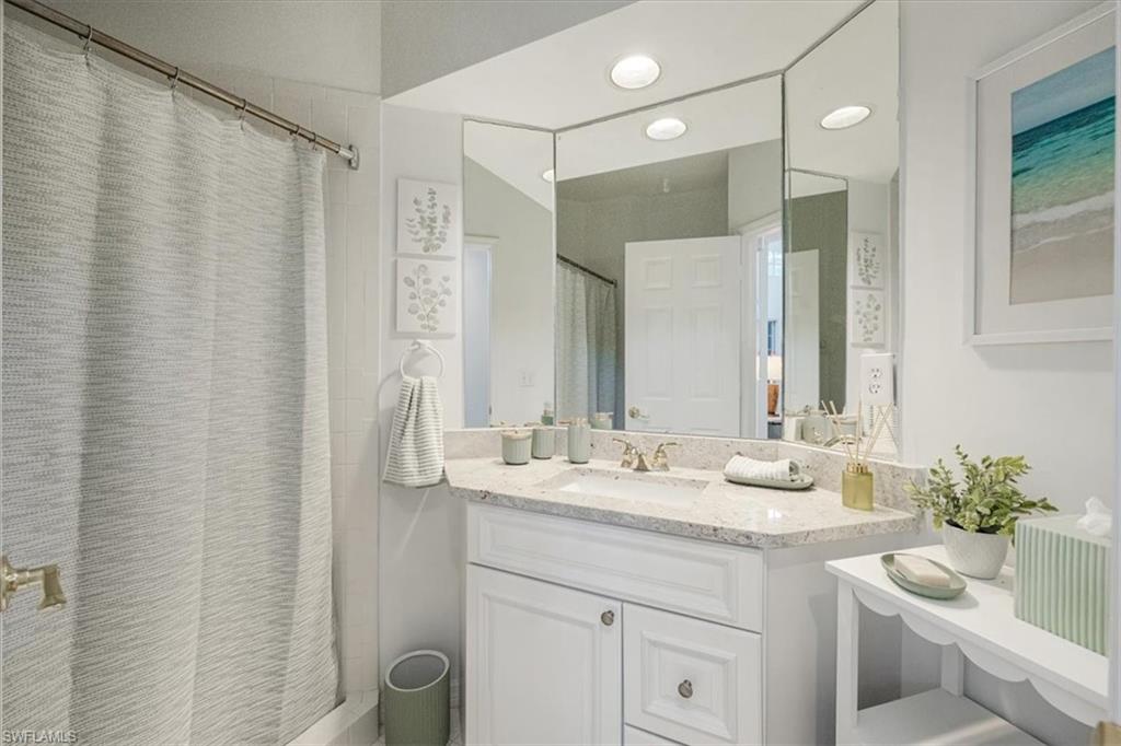 Bathroom featuring a shower with curtain and vanity
