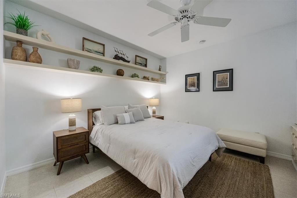 Bedroom with ceiling fan and light tile patterned floors