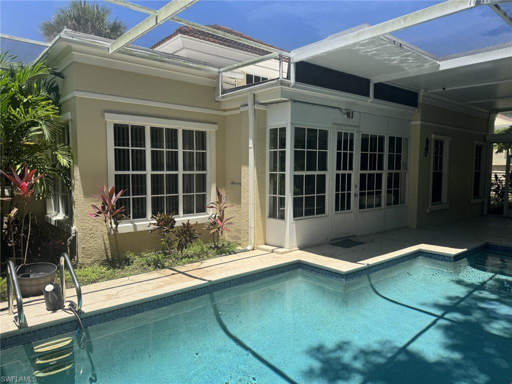 Swimming pool featuring a patio area and glass enclosure