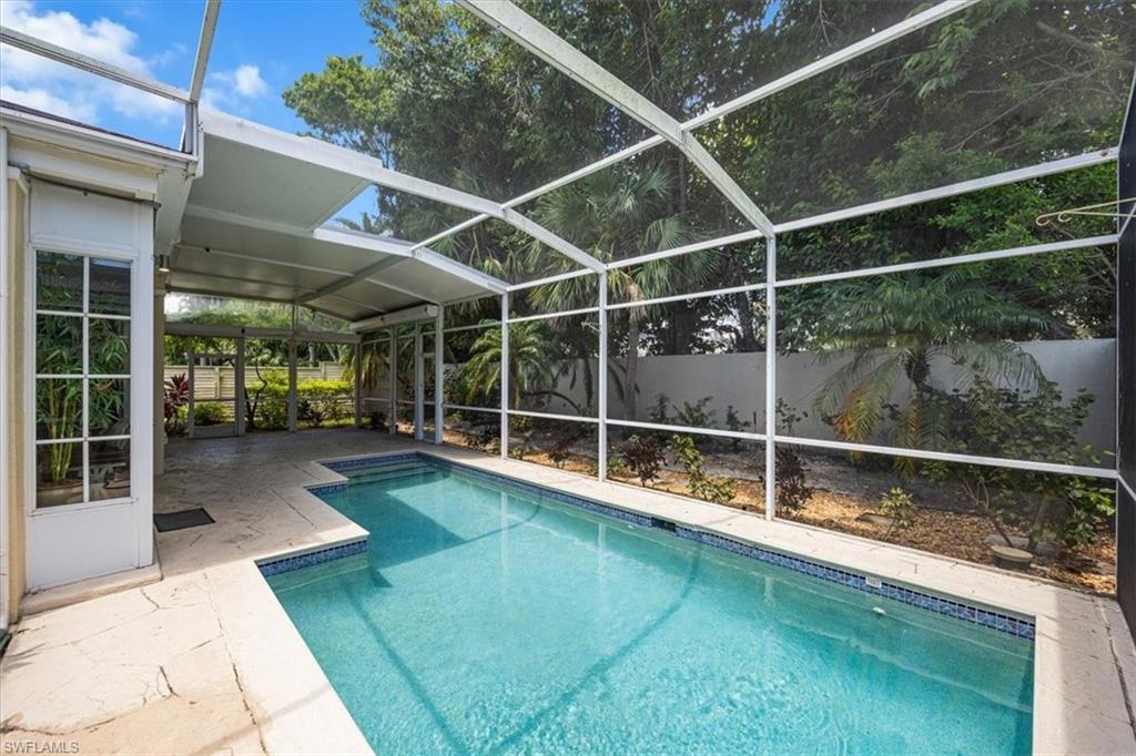View of pool featuring a lanai, a sunroom, and a patio