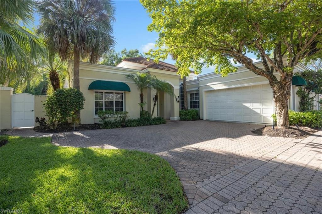 Mediterranean / spanish-style home with a gate, decorative driveway, stucco siding, a garage, and a front yard