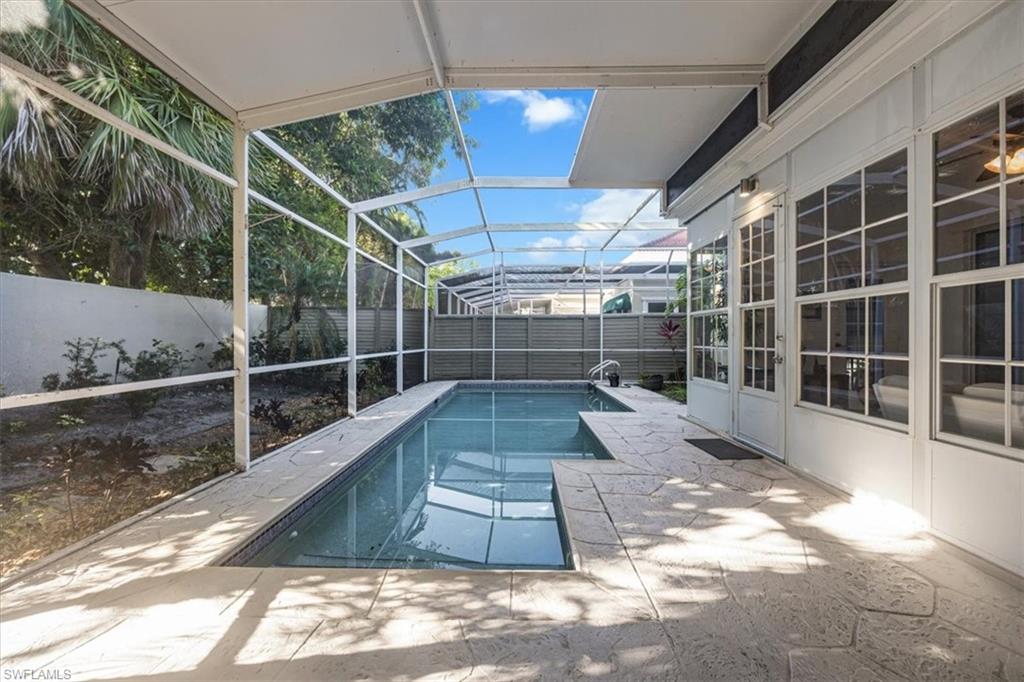 View of pool featuring a sunroom, a fenced backyard, a patio area, and a lanai