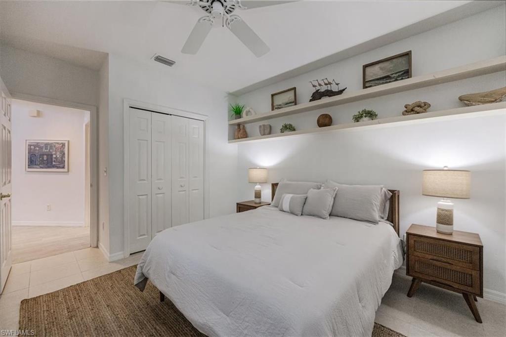 Bedroom with a closet, ceiling fan, and light tile patterned floors