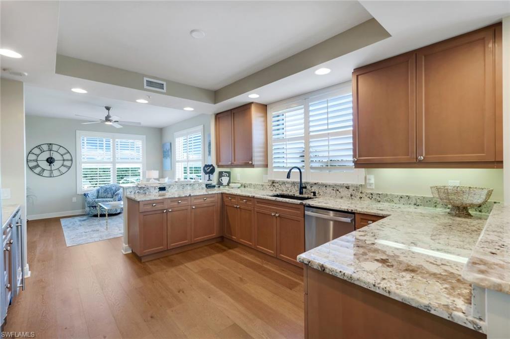 Gorgeous warm wood cabinets and wood flooring in kitchen with updated counters