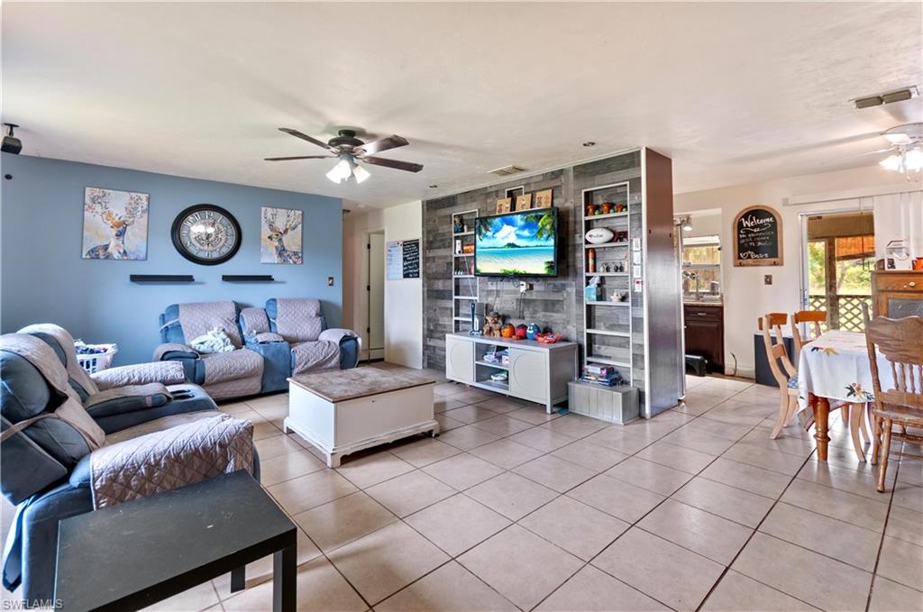 Living area with ceiling fan and light tile patterned flooring