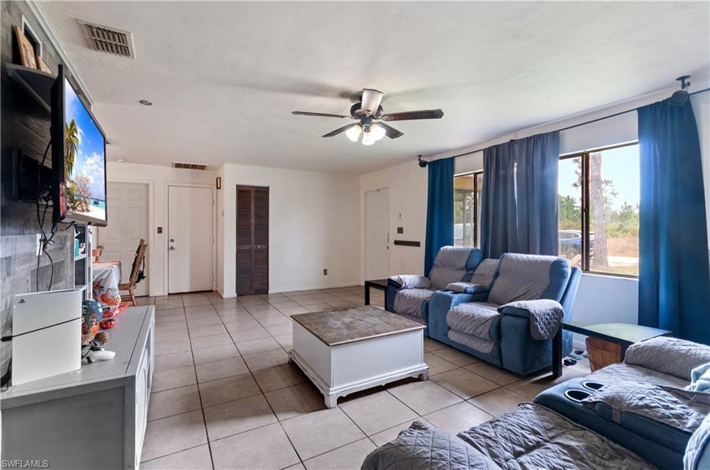 Living area featuring light tile patterned flooring and a ceiling fan