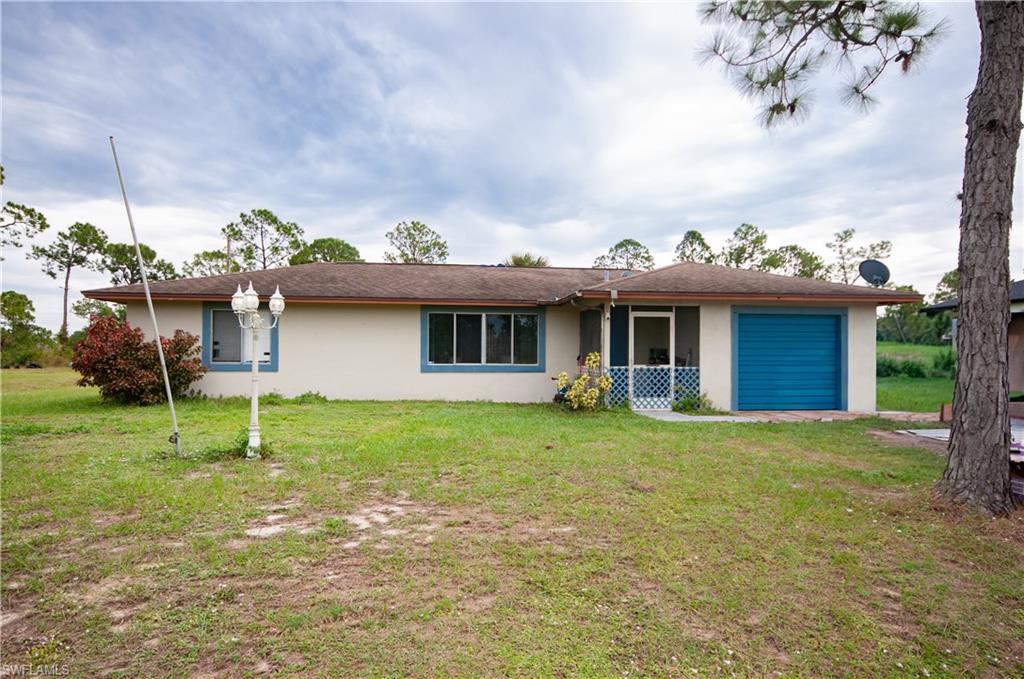 Single story home featuring a garage, stucco siding, and a front lawn