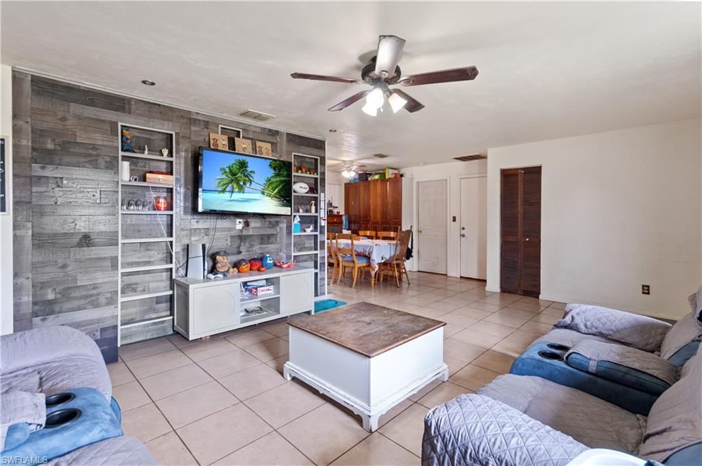 Living area with tile patterned floors and ceiling fan