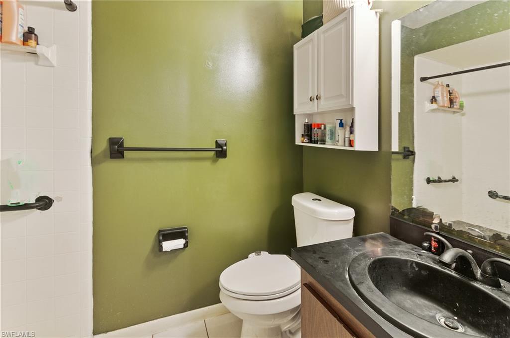 Full bath featuring a shower, vanity, and tile patterned flooring