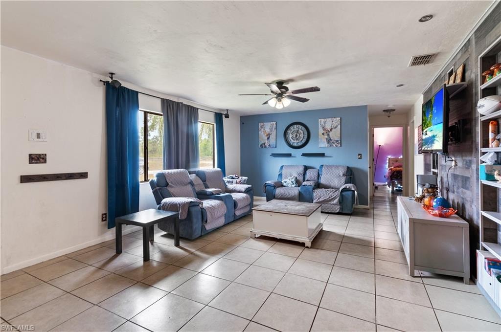 Living area with ceiling fan and light tile patterned floors