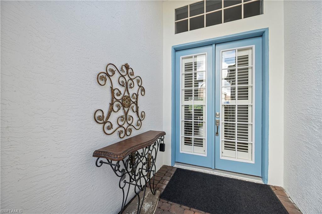 View of exterior entry featuring stucco siding and french doors