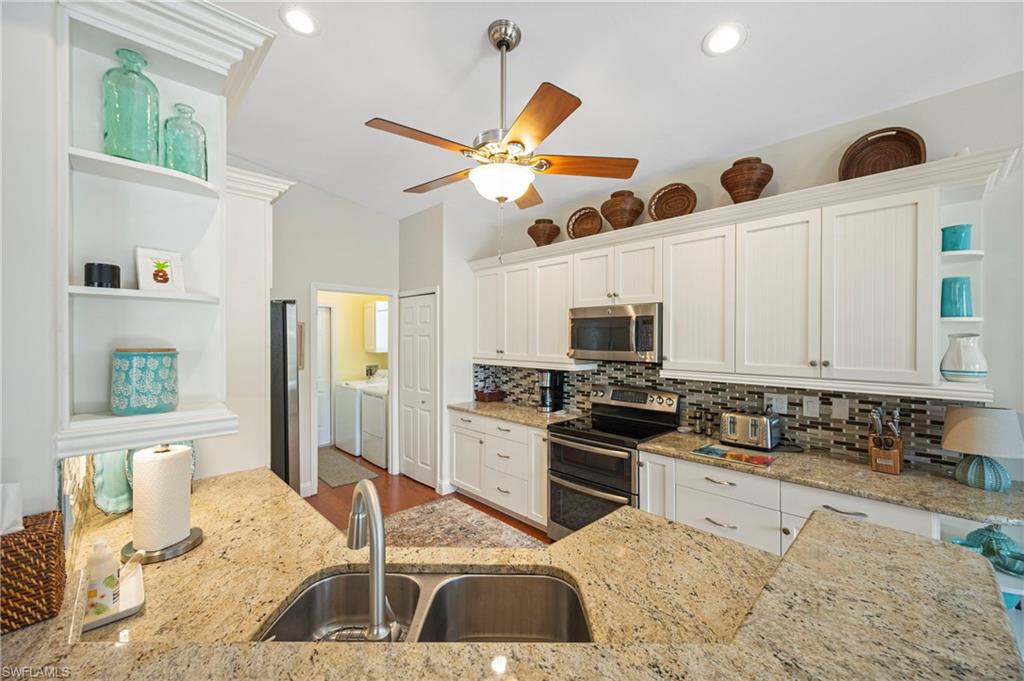 Kitchen with open shelves, white cabinetry, appliances with stainless steel finishes, backsplash, and recessed lighting