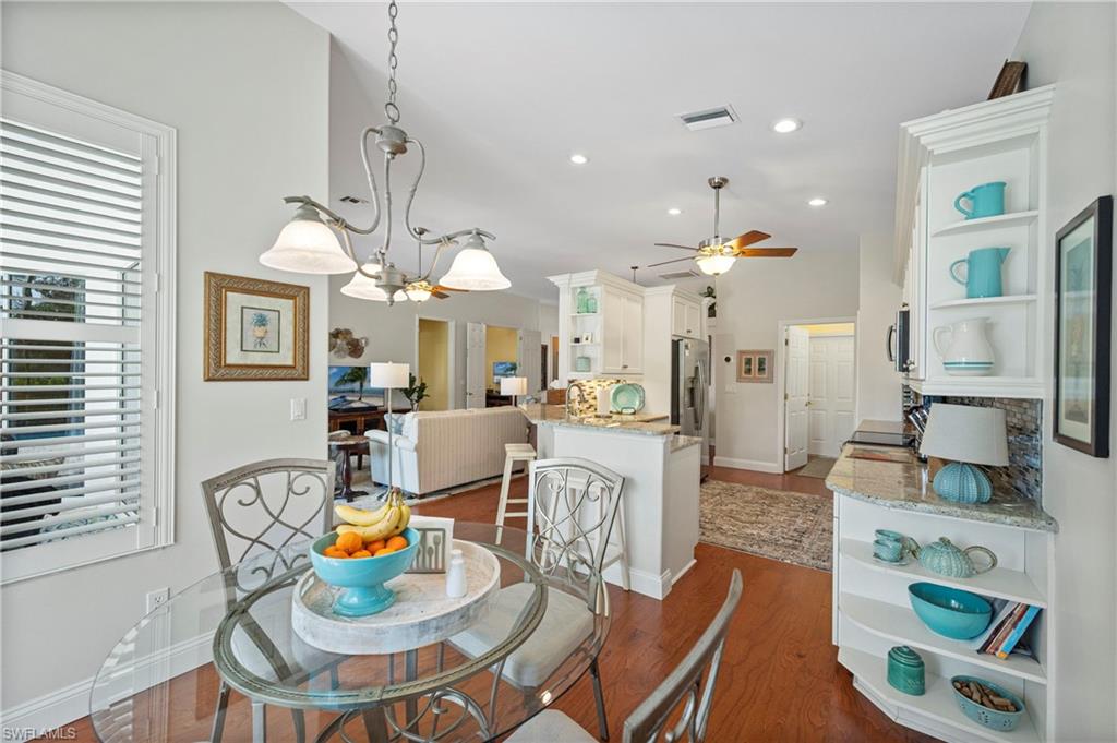 Dining space featuring dark wood-style floors, recessed lighting, a chandelier, and a ceiling fan