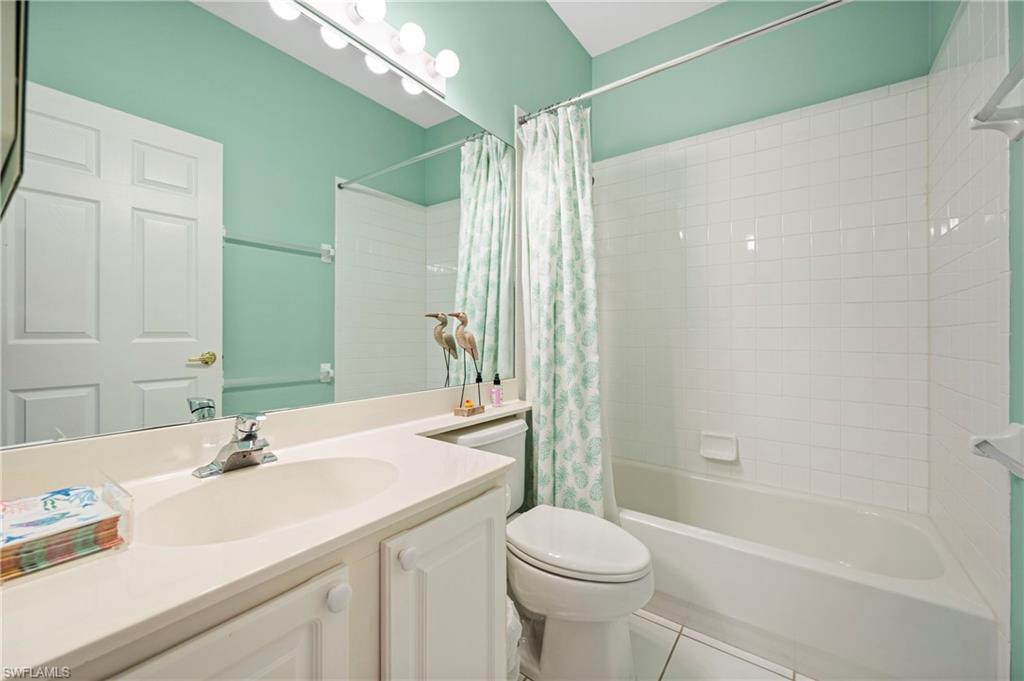 Full bath with shower / bath combination with curtain, tile patterned flooring, and vanity