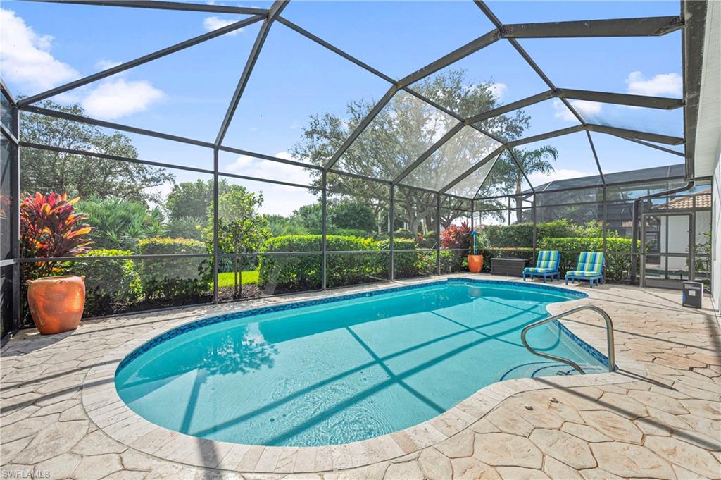 Swimming pool featuring glass enclosure, a sunroom, and a patio area