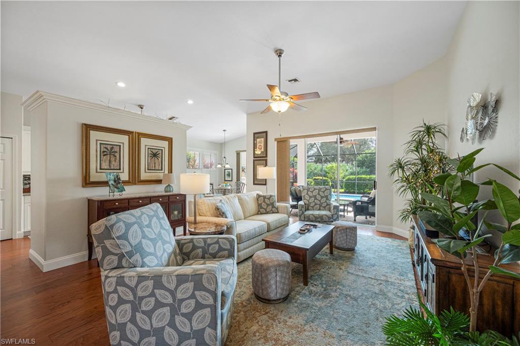 Living room with wood finished floors, a ceiling fan, recessed lighting, and lofted ceiling