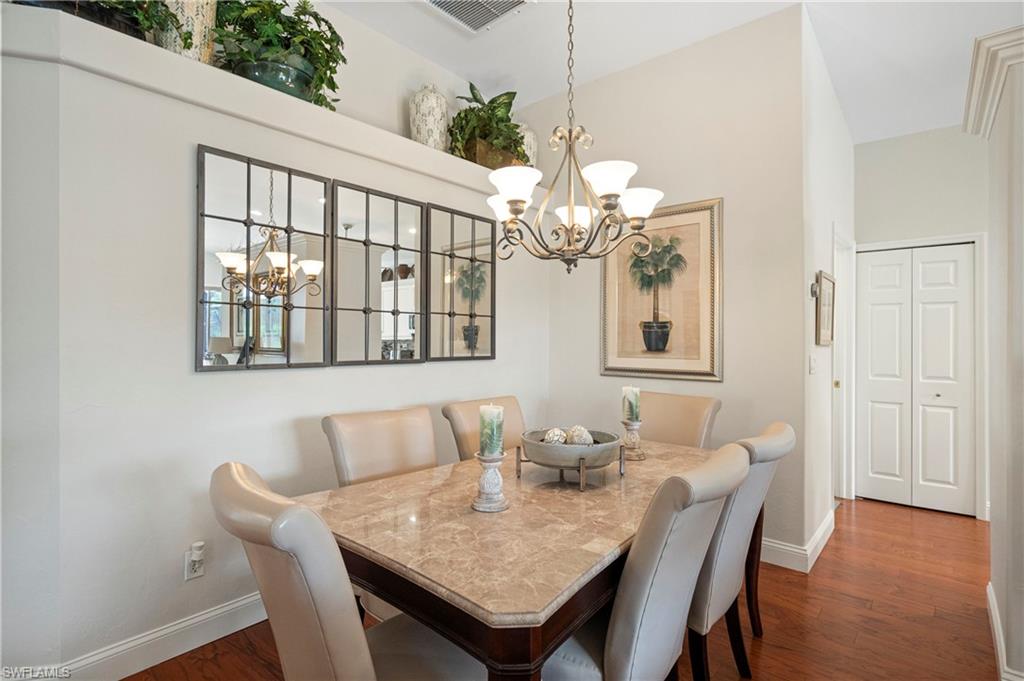 Dining area featuring a chandelier and dark wood-type flooring