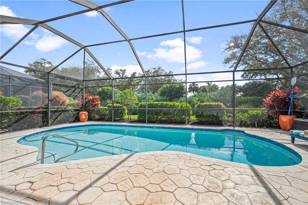 Outdoor pool featuring a sunroom and glass enclosure