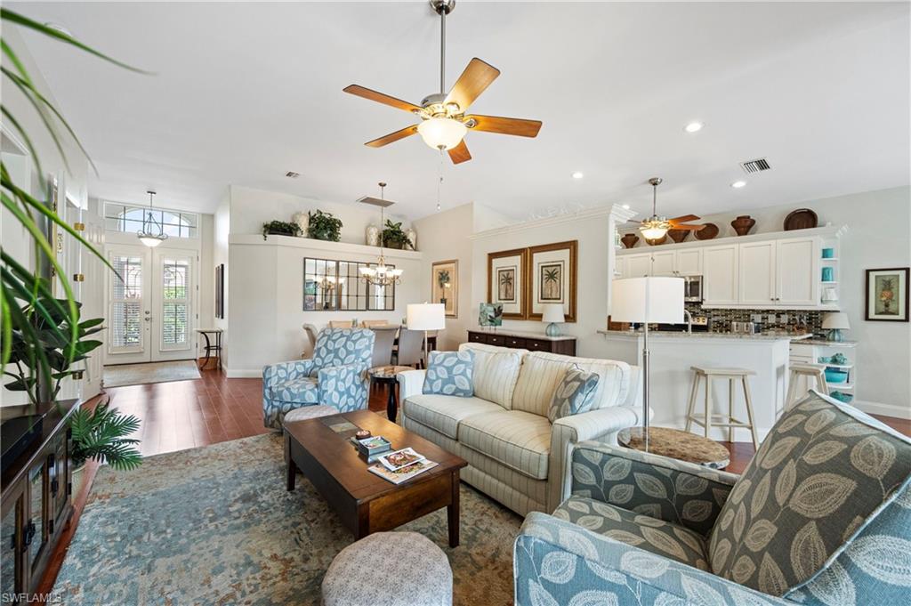 Living room with a chandelier, wood finished floors, a ceiling fan, french doors, and recessed lighting