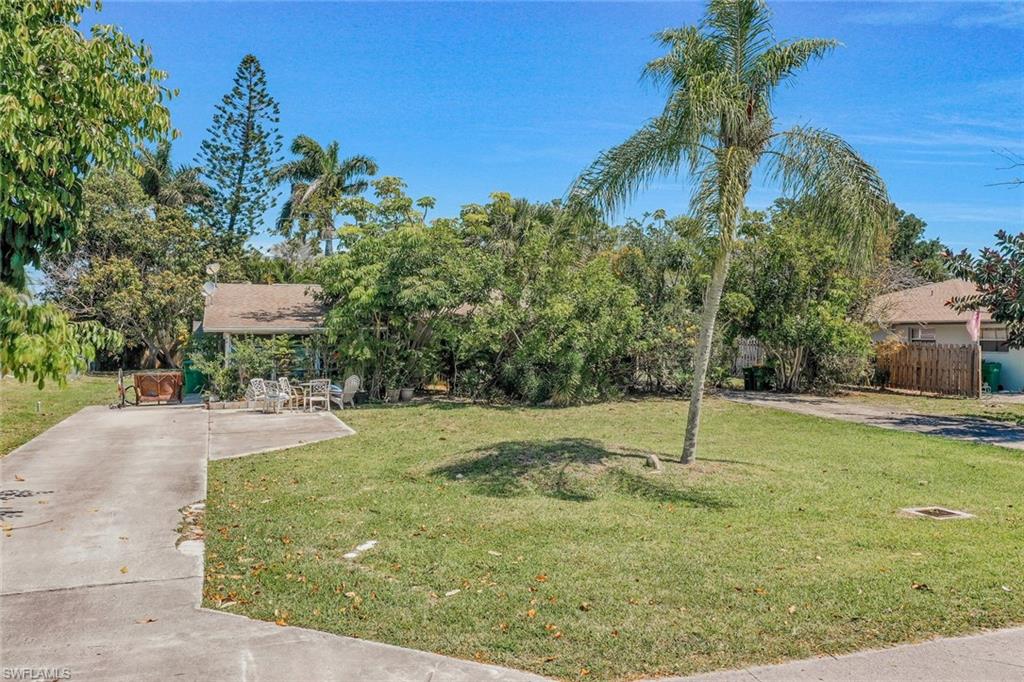 View of property hidden behind natural elements featuring a patio
