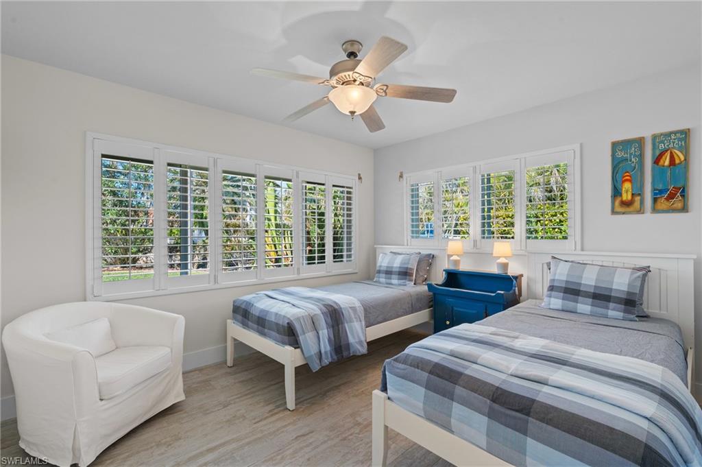 Bedroom with wood look tile floors and ceiling fan