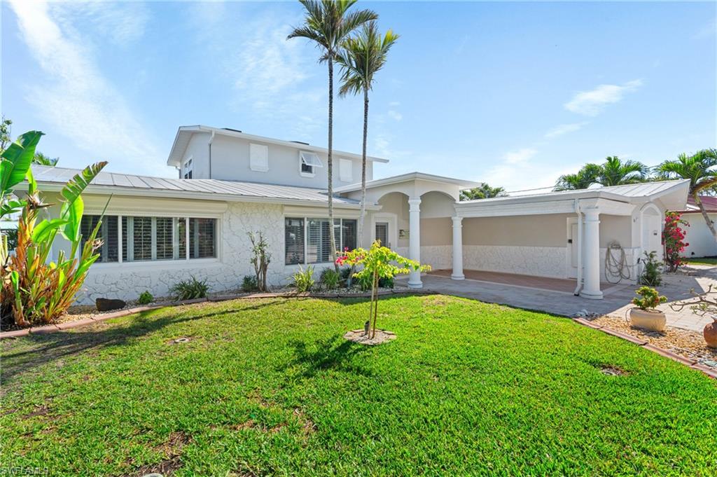 View of front of property with a carport and a front yard -Virtually enhanced image
