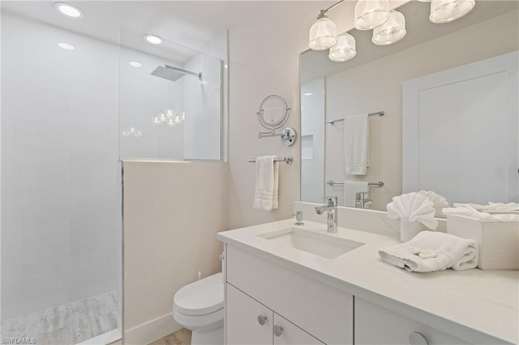 Bathroom featuring vanity, toilet, and a tile shower