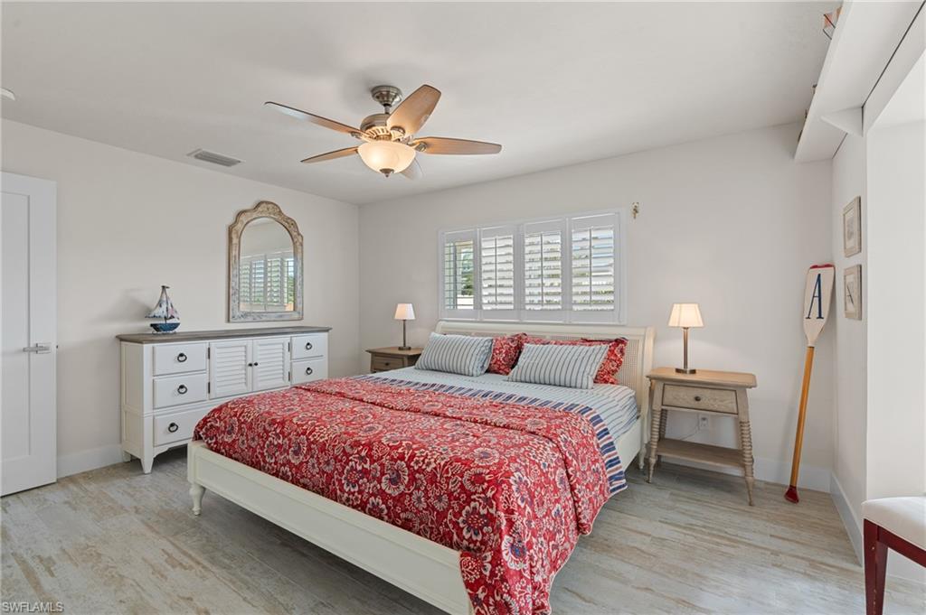 Bedroom with ceiling fan and light wood look tile flooring