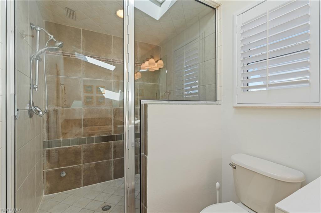 Bathroom with a skylight, walk in shower, and toilet