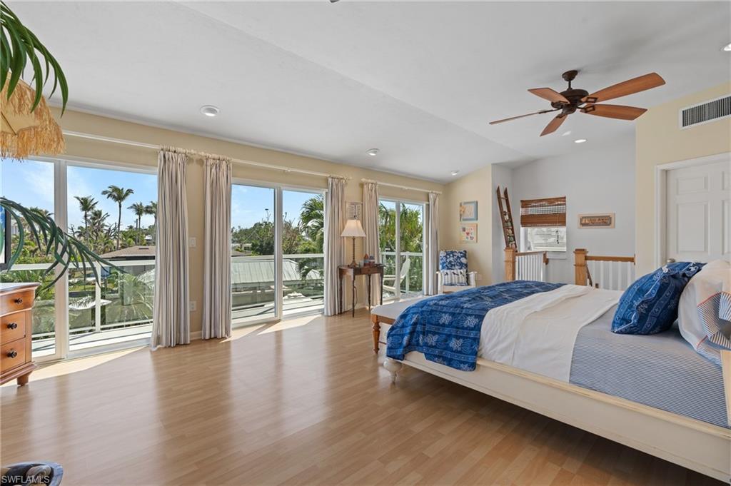 Bedroom featuring vaulted ceiling, access to exterior, and light wood look tile floors