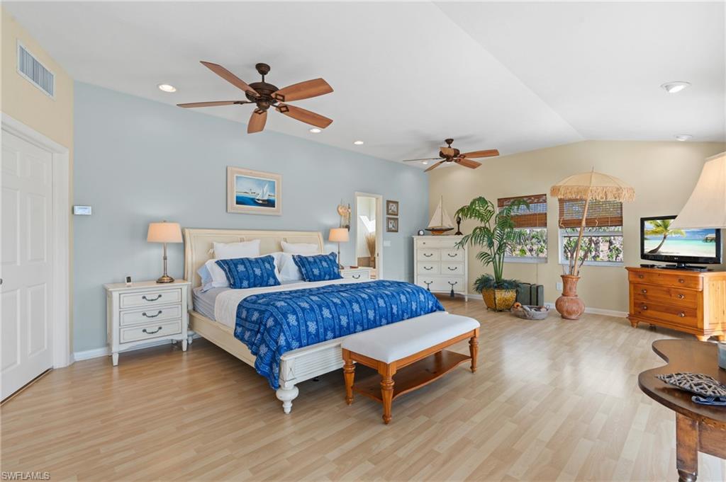 Bedroom with lofted ceiling, ceiling fan, and light wood look tile flooring