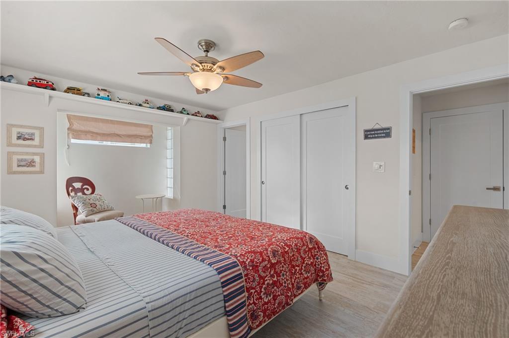 Bedroom with ceiling fan, a closet, and light wood look tile flooring