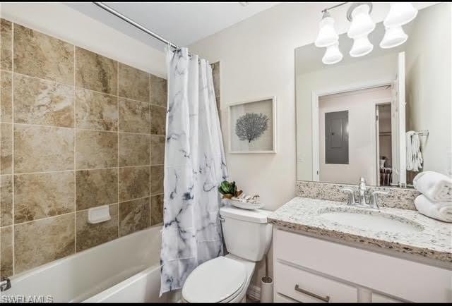 Bathroom featuring shower / bath combo, vanity, a chandelier, and electric panel