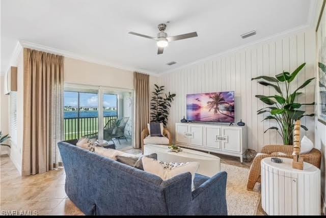 Living area with ornamental molding, ceiling fan, and wood walls