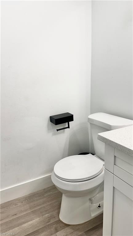 Half bathroom with wood finished floors and vanity