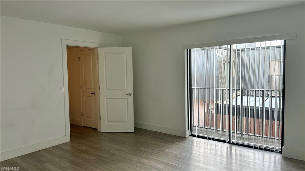 Unfurnished room featuring baseboards and wood finished floors