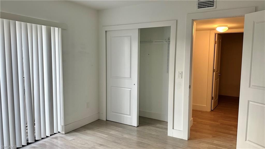 Unfurnished bedroom with light wood-style flooring and a closet