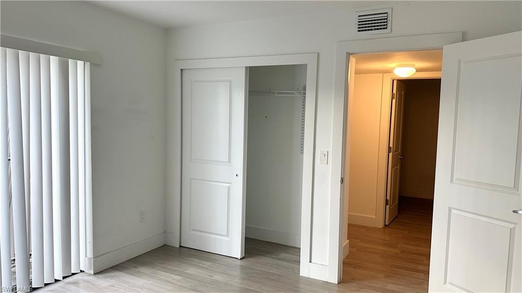 Unfurnished bedroom featuring light wood finished floors and a closet