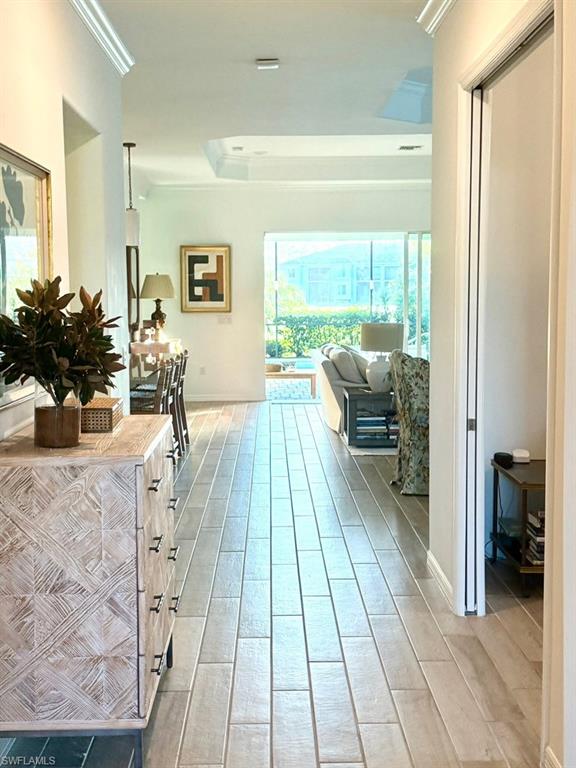 Hall featuring wood finish floors, ornamental molding, and recessed lighting