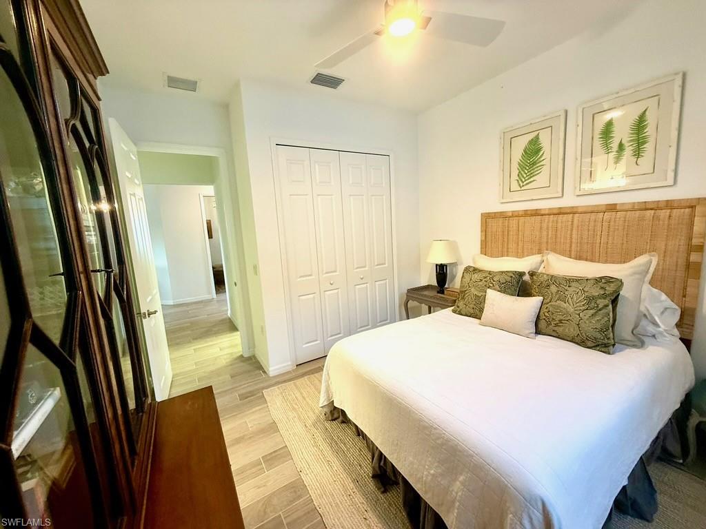 Living area with a tray ceiling, light wood-type flooring, crown molding, recessed lighting, and a chandelier