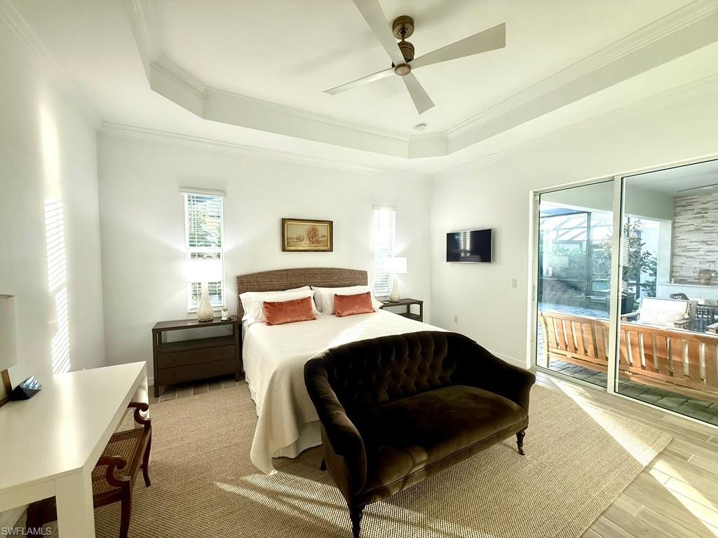 Kitchen featuring stone tile floors, wall chimney range hood, high end fridge, and crown molding