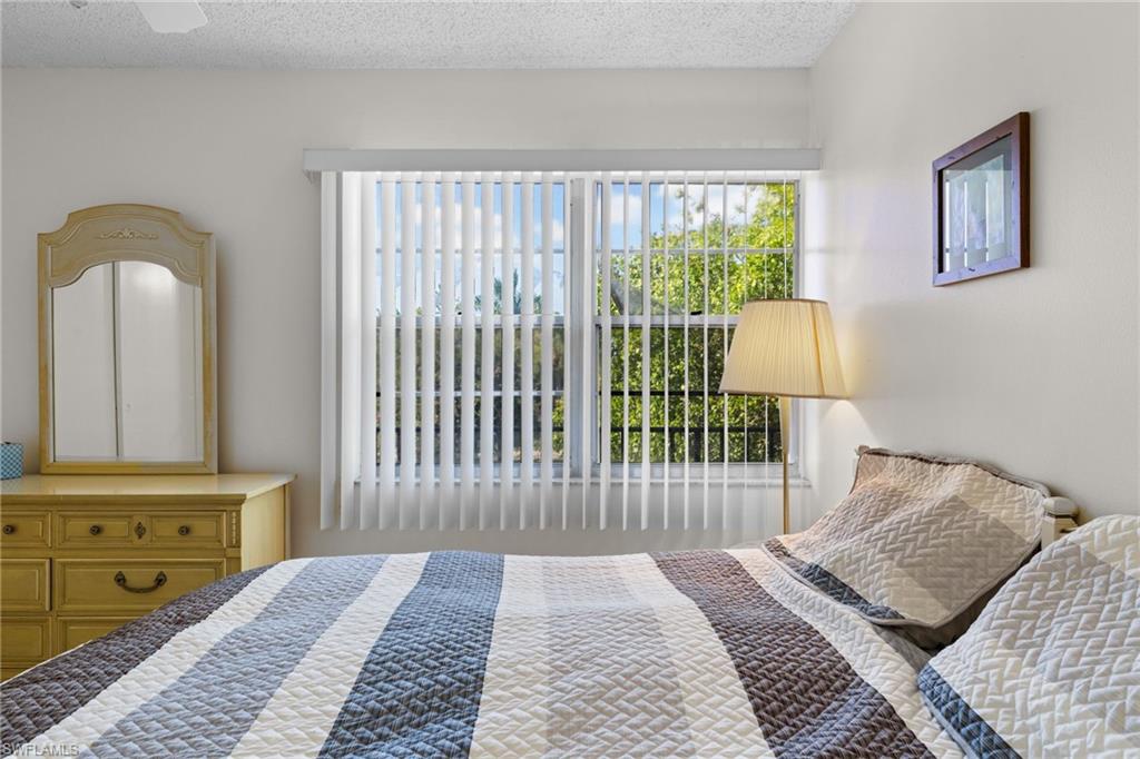 Bedroom with a textured ceiling and a ceiling fan