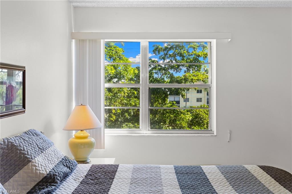 Bedroom with multiple windows and a textured ceiling