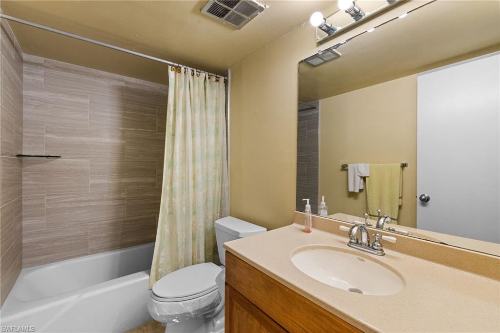 Full bath featuring vanity and shower / bath combo with shower curtain